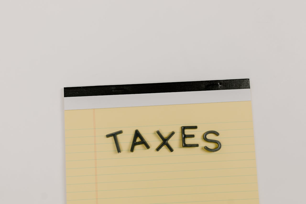 about-us A flat lay of the word 'TAXES' on a yellow notepad, ideal for financial content.